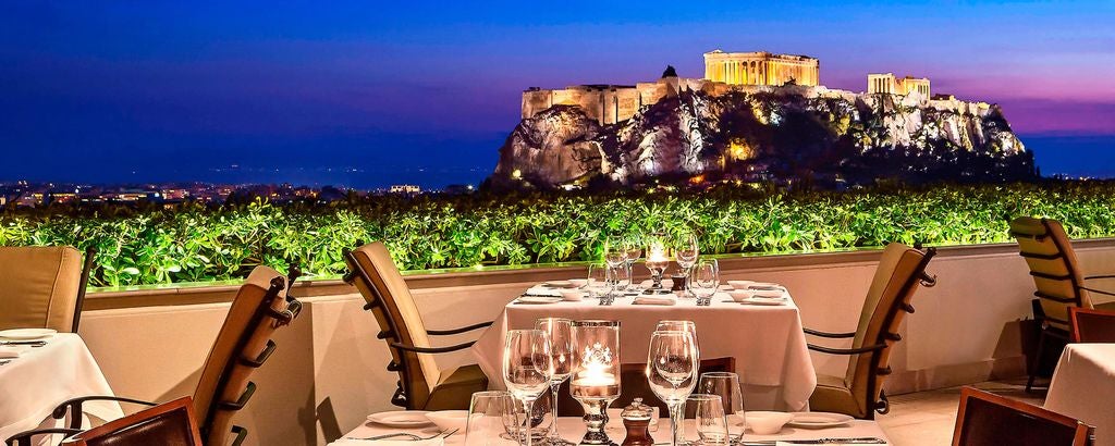 Historic Hotel Grande Bretagne in Athens features neoclassical architecture with ornate stone facades, elegant windows and luxury entrance details