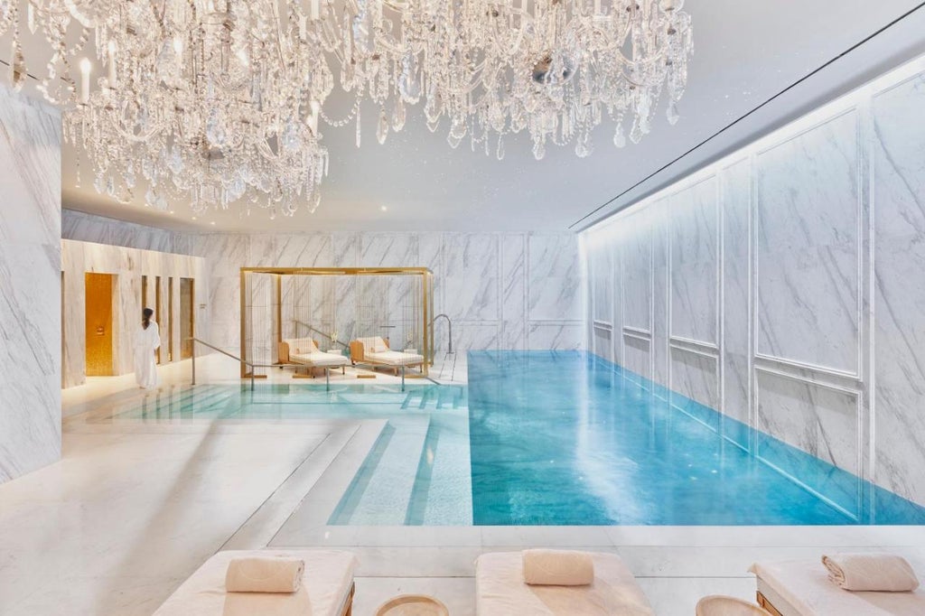 Opulent lobby of Mandarin Oriental Ritz Madrid with crystal chandeliers, gilded columns, plush seating, and ornate marble flooring