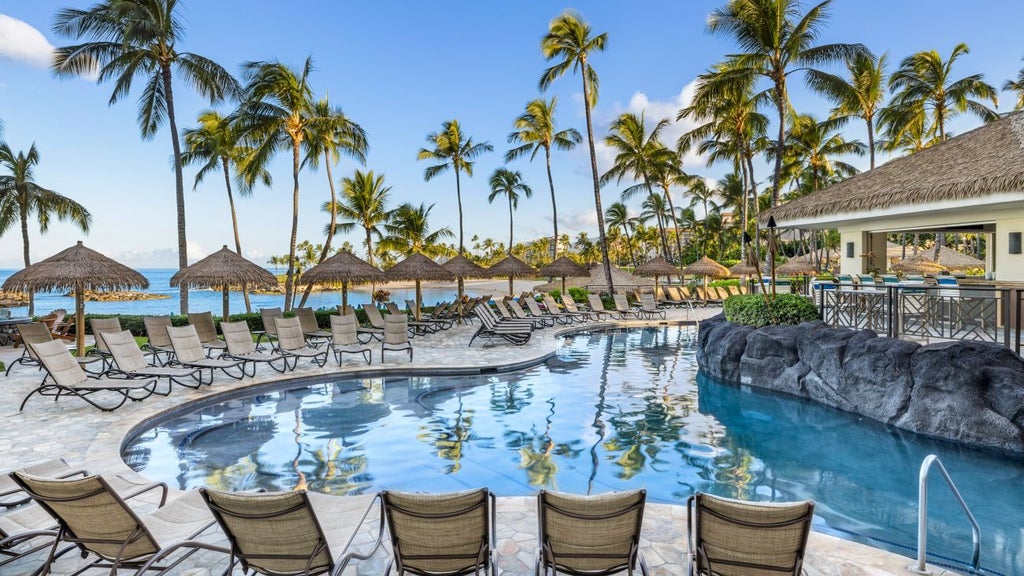 Luxurious beachfront resort at Ko Olina, Hawaii, with pristine white sandy beach, turquoise waters, and elegant Marriott resort buildings nestled in tropical landscape