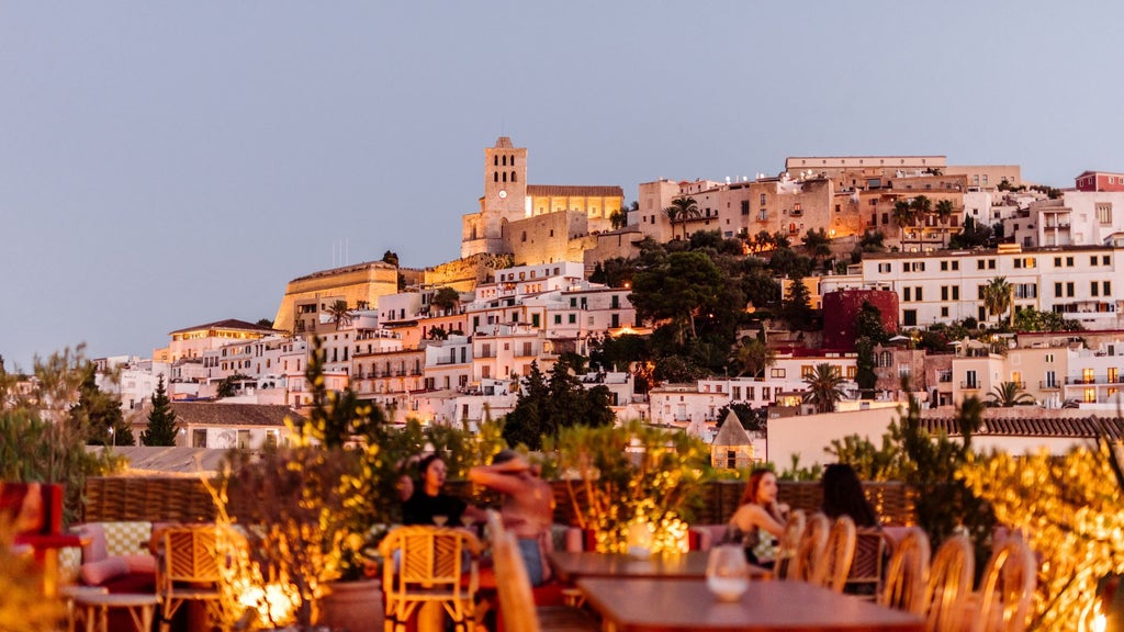 Elegant white-washed Mediterranean hotel nestled in scenic landscape, featuring minimalist architecture and sun-drenched terrace with panoramic coastal views of Spanish scenery