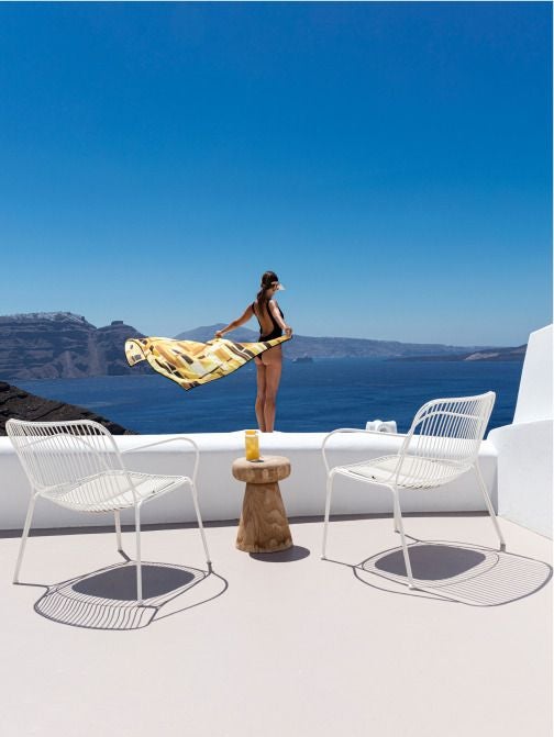 Luxurious white-washed Scenset hotel overlooking azure Aegean Sea, with infinity pool, minimalist design, and stunning Santorini sunset backdrop