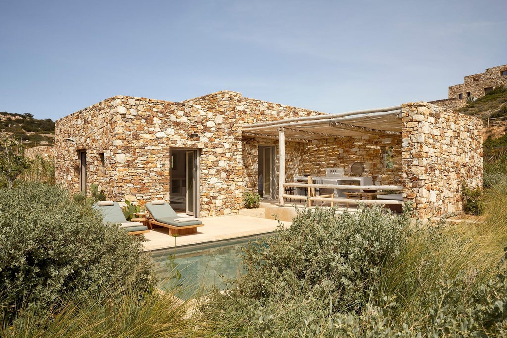 Minimalist stone villa with private infinity pool overlooking the Aegean Sea, featuring natural textures and pristine Greek landscape