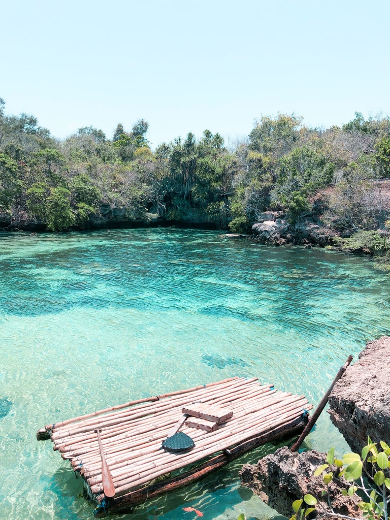 Luxurious beachfront resort with minimalist design, infinity pool overlooking turquoise waters, and lush tropical landscape at Cap Karoso, Indonesia