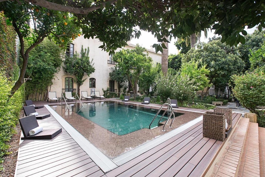 Historic Spanish luxury hotel with grand arched courtyard, marble columns and elegant terracotta facade in warm evening light