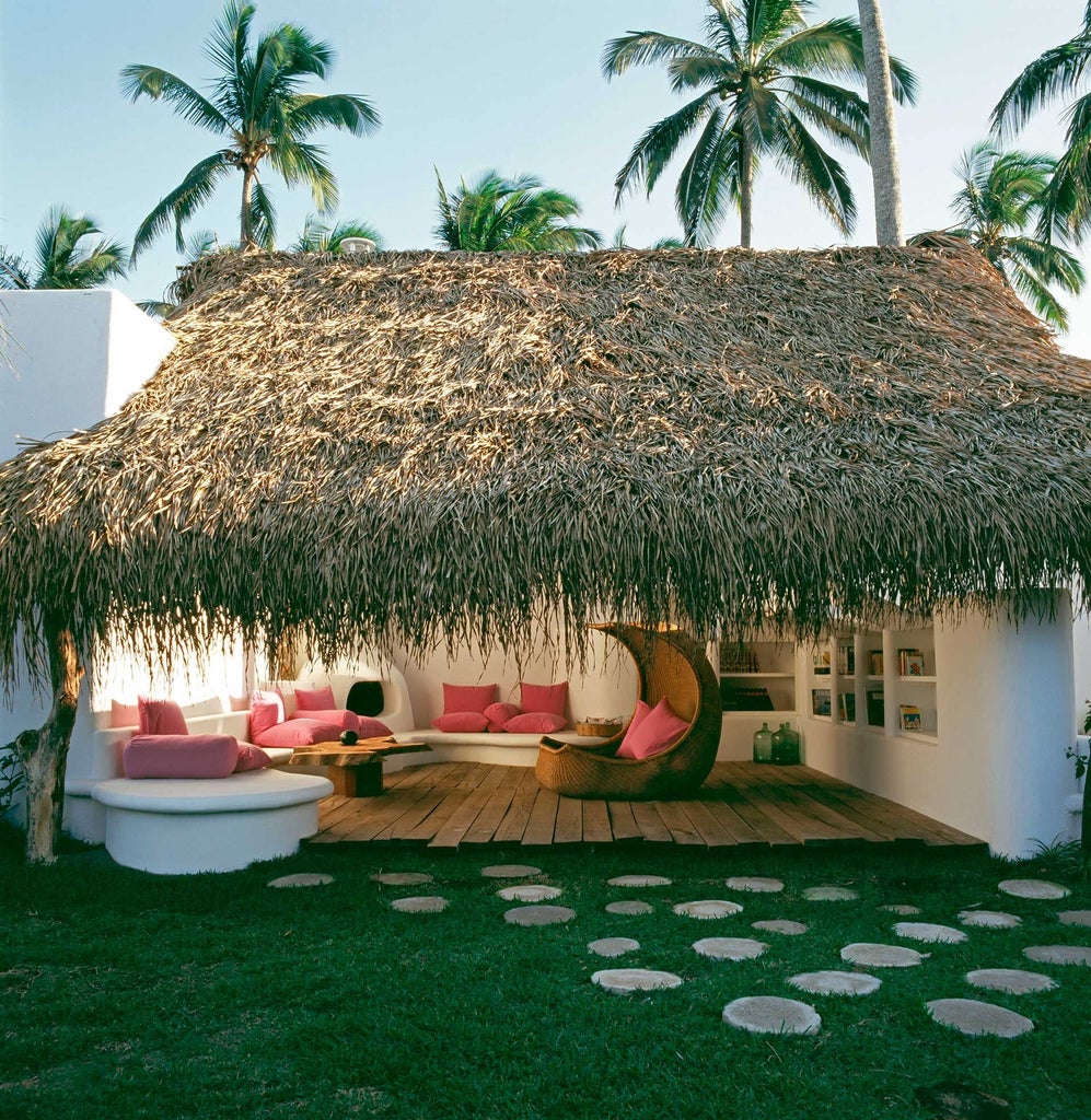 Luxurious white hotel nestled on a tropical cliff overlooking turquoise waters, featuring modern architecture with sweeping curves and elegant minimalist design