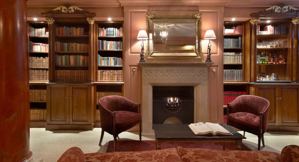 Elegant Georgian townhouse hotel exterior with classic white facade, large windows, and ornate architectural details in central London setting