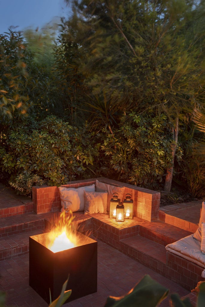 Elegant stone country house with terracotta roof, surrounded by lush green gardens and rolling hills of rural Portugal at golden hour