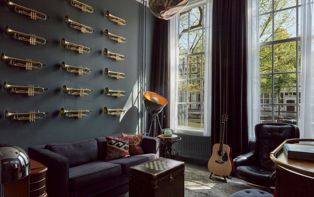 Classical Dutch canal house suite with grand piano, vintage record player, leather armchair and floor-to-ceiling windows overlooking Amsterdam