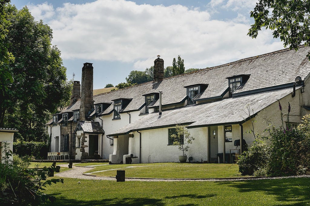 Luxurious stone farmhouse nestled in rolling green countryside, traditional Scenset architecture with rustic charm and elegant stone walls in rural United Kingdom