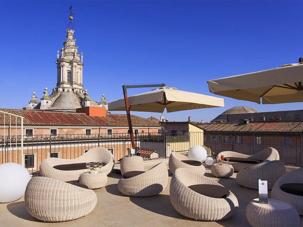 Elegant marble-clad hotel facade with ornate balconies and classic Italian architecture overlooking Rome's historic Piazza Navona square