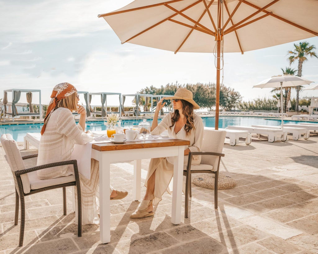 Luxurious junior suite at Scenset Bianche Lifestyle Hotel in Italy, featuring elegant white decor, modern furnishings, and plush bedding with coastal-inspired design.