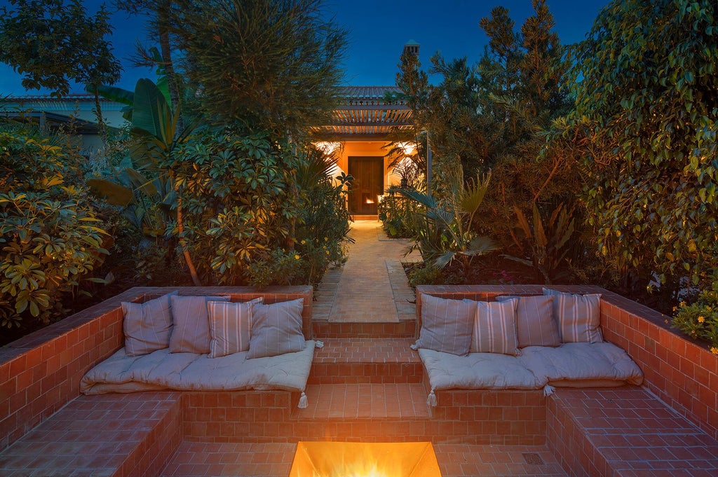 Luxurious stone country house with manicured gardens, terracotta roof, and rolling hills of Portuguese countryside at golden hour