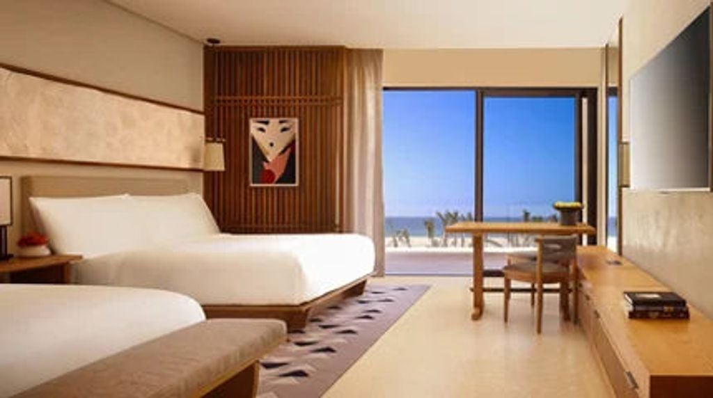 Modern luxury swim-up suite with private terrace, minimalist decor, ocean views, and direct pool access at Nobu Los Cabos resort