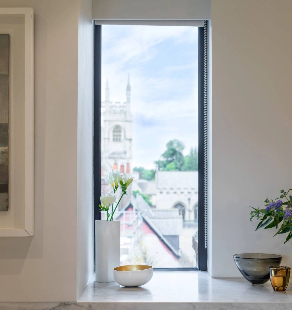 Elegant heritage hotel room with expansive windows overlooking historic streets, blending luxurious vintage furnishings and warm wooden accents in a refined British setting