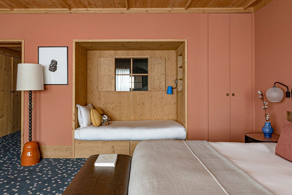 Luxurious alpine ski resort prestige junior suite with elegant wood paneling, plush white bedding, and expansive mountain view through large windows