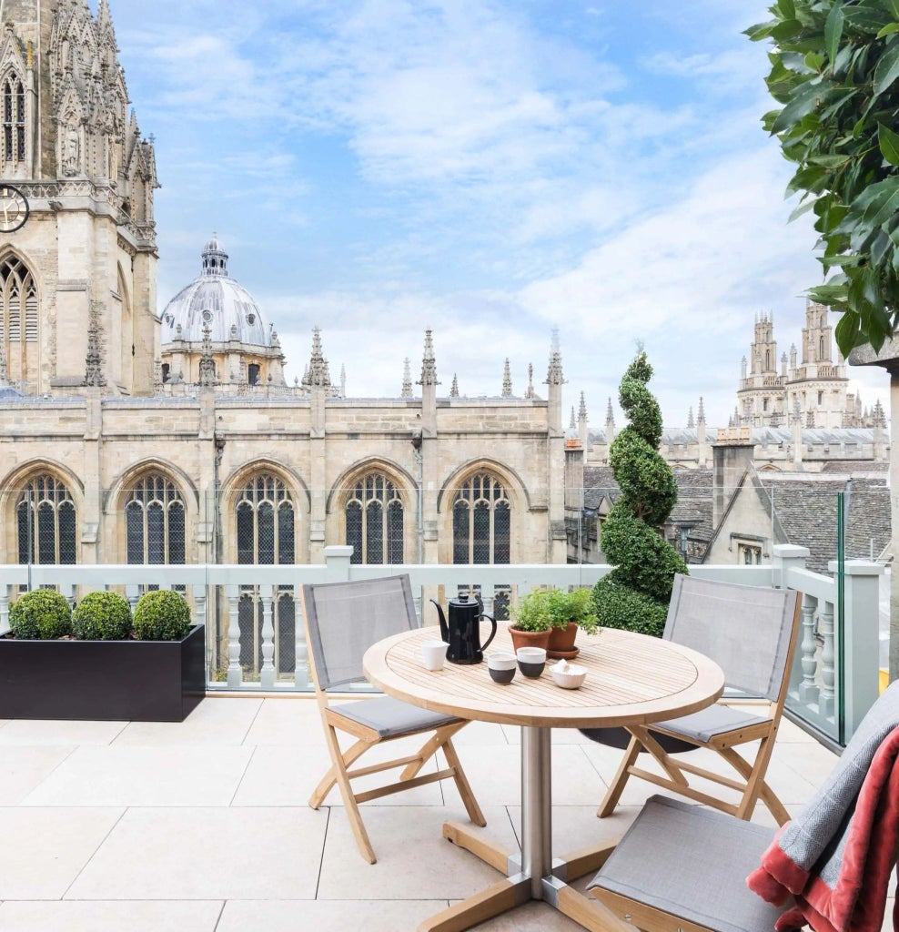 Elegant period room with large windows, antique furnishings, soft neutral palette, vintage bank ledgers, and classic British hotel design showcasing historic architectural details