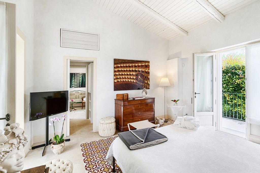 Elegant Sicilian stone-walled hotel room with rustic four-poster bed, luxurious white linens, and minimalist antique-inspired decor in warm neutral tones