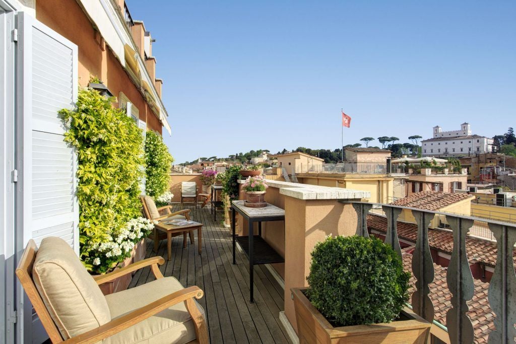 Luxurious penthouse suite overlooking scenic Italian landscape, featuring opulent marble floors, modern furnishings, and expansive floor-to-ceiling windows in Roma