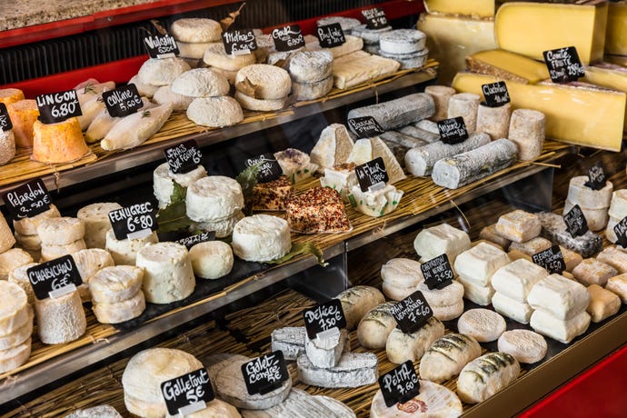 Visit a cheese shop with a guide to learn about and taste various cheese styles from France.
