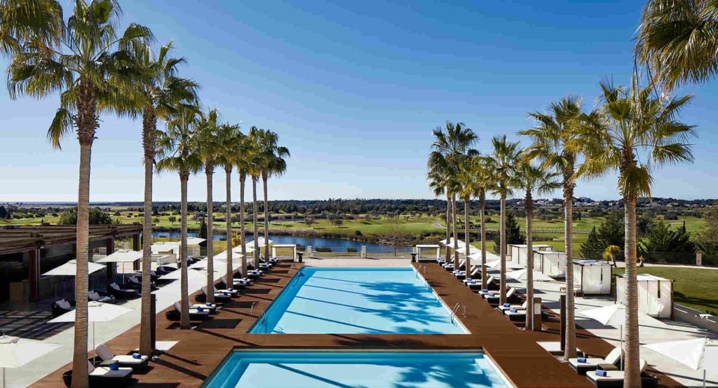 Elegant five-star resort with contemporary white architecture, infinity pools and manicured gardens overlooking Algarve golf courses