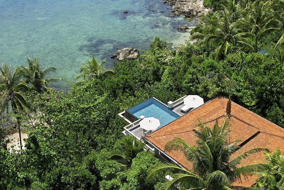 Luxurious oceanfront pool villa at Trisara resort featuring an infinity pool merging with Andaman Sea views, surrounded by tropical gardens