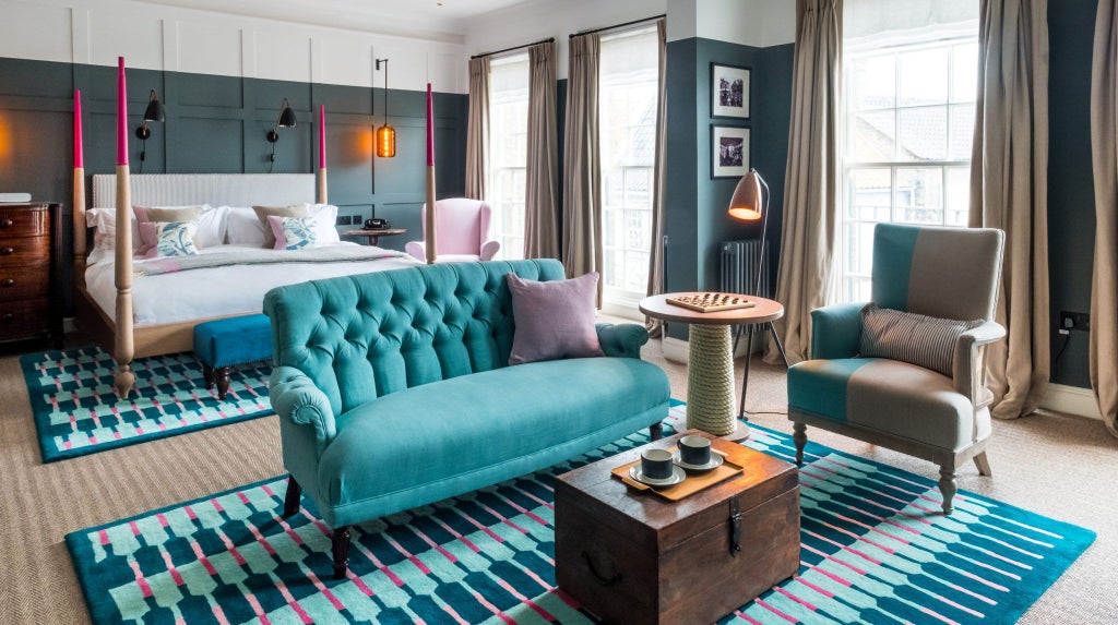 Elegant coastal hotel room with crisp white linens, soft neutral tones, large windows, and panoramic sea view at The Swan in Southwold, UK.