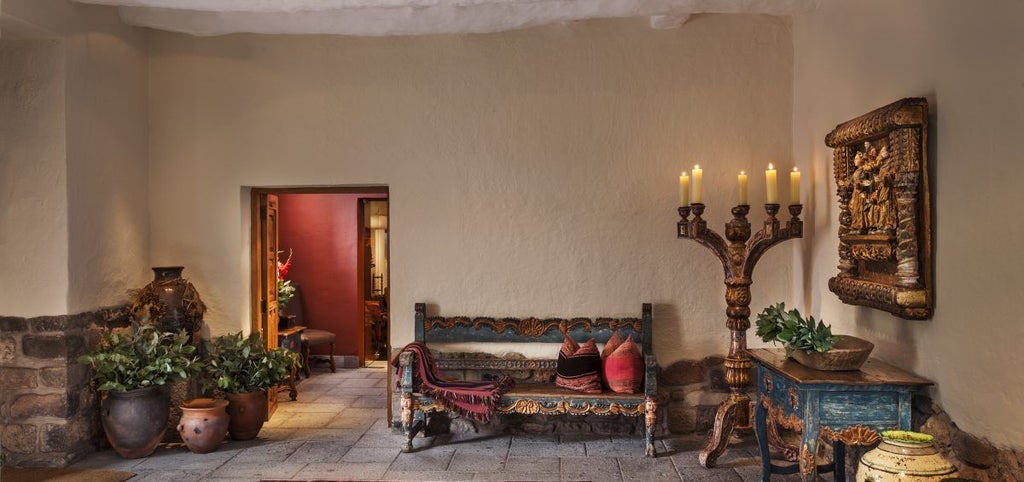 Spanish colonial mansion with stone archways and ornate wooden balconies, featuring manicured courtyard garden and elegant period decor