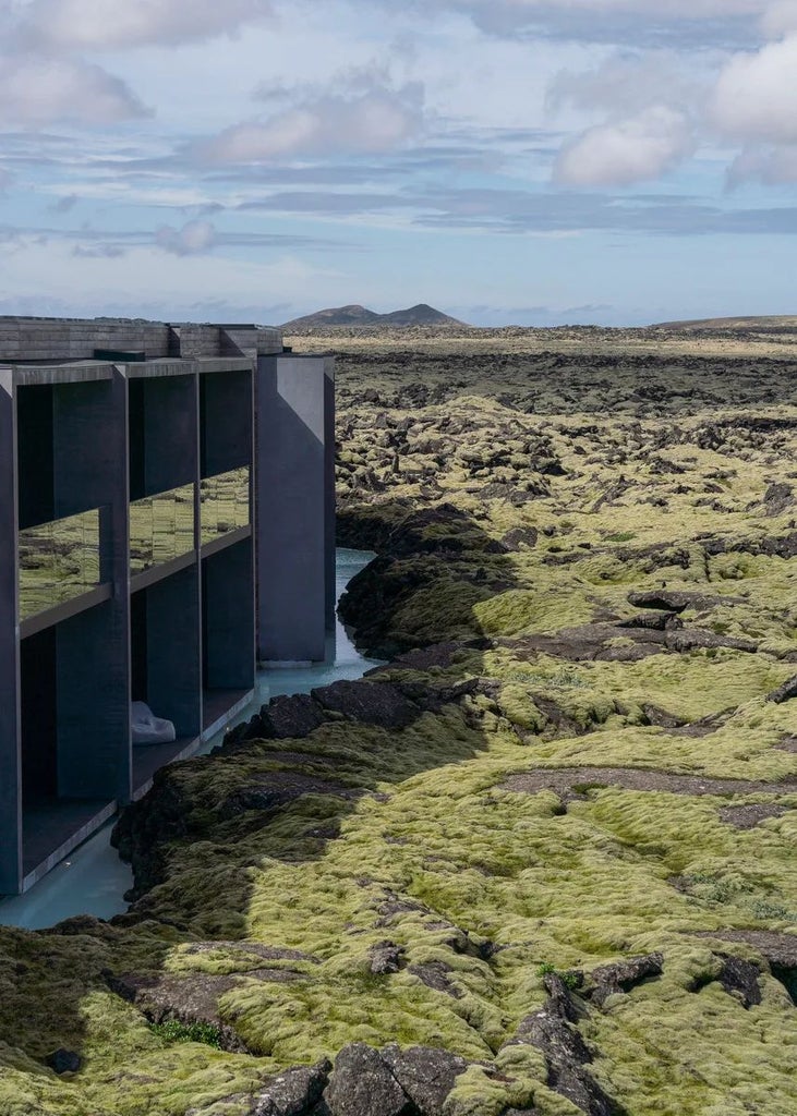 Luxurious Lagoon Suite with panoramic windows overlooking Iceland's dramatic landscape, featuring minimalist Nordic design and soft, neutral color palette