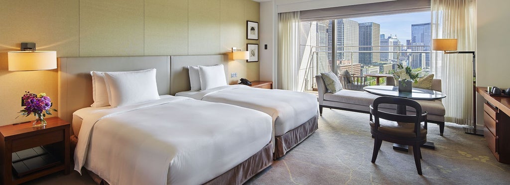 Luxurious hotel room at Palace Hotel Tokyo with elegant twin/king bed, floor-to-ceiling windows overlooking Wadakura Fountain Park, modern decor, and private balcony