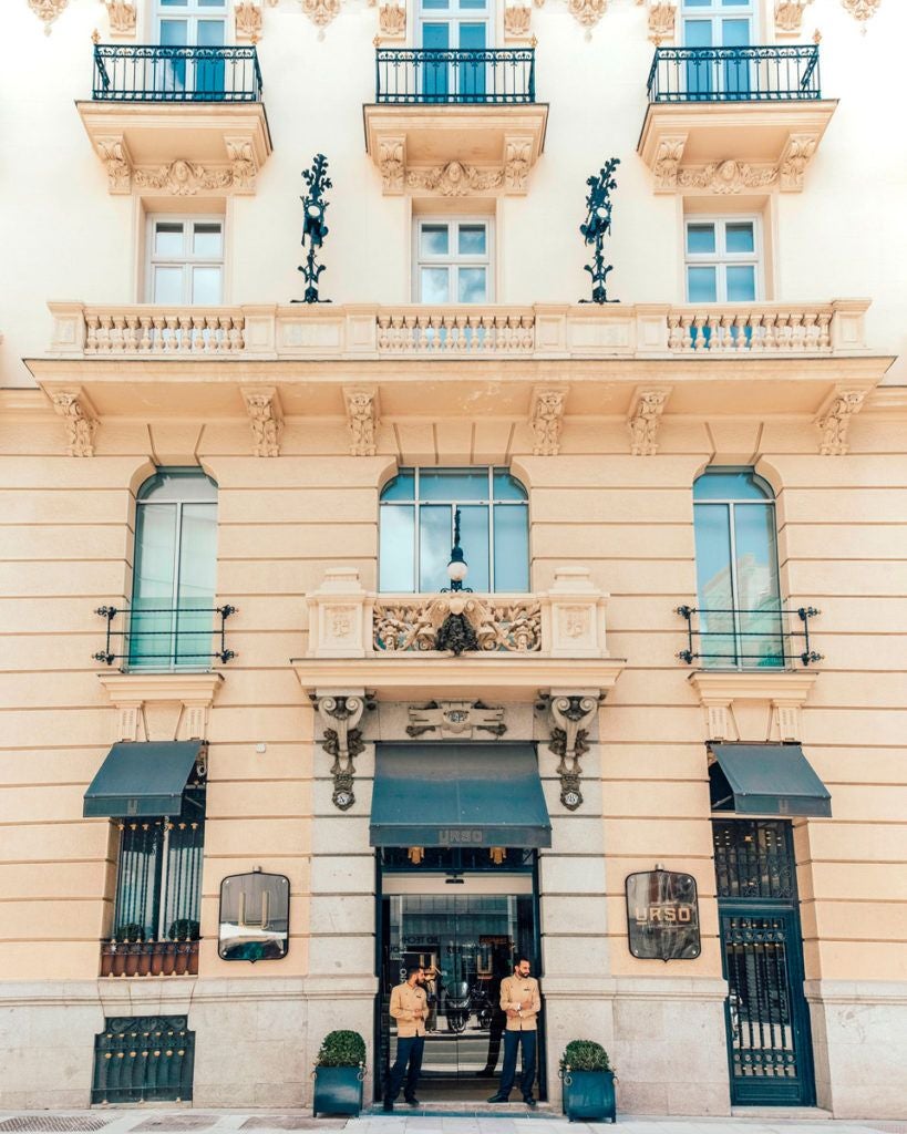 Elegant boutique hotel with marble columns, luxurious lobby, soft neutral tones, and vintage Spanish architectural details in central Madrid