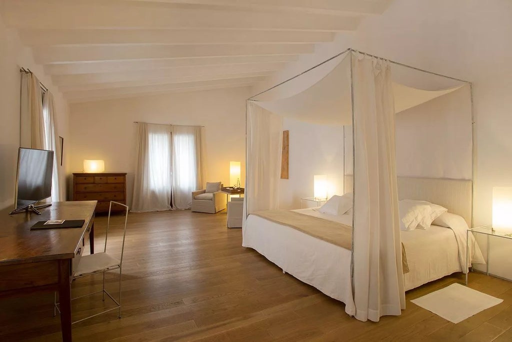 Elegant premium suite at historic Convent de la Missió, featuring minimalist design with stone walls, plush white bedding, and refined Mediterranean architectural details.