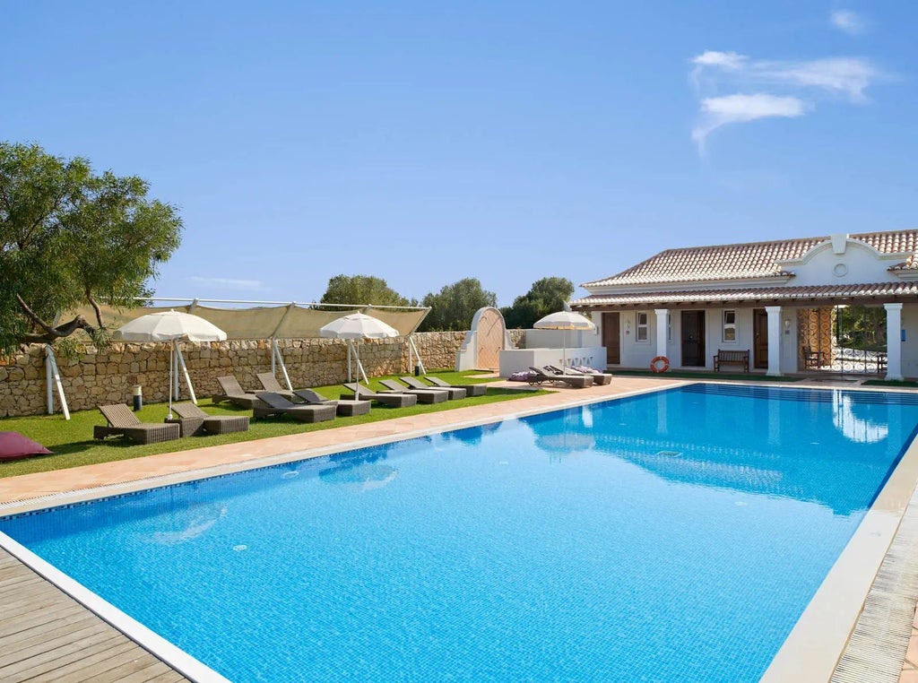 Spacious, modern villa bedroom at Martinhal Sagres Beach Family Resort with elegant white decor, large windows, and panoramic coastal views in Portugal