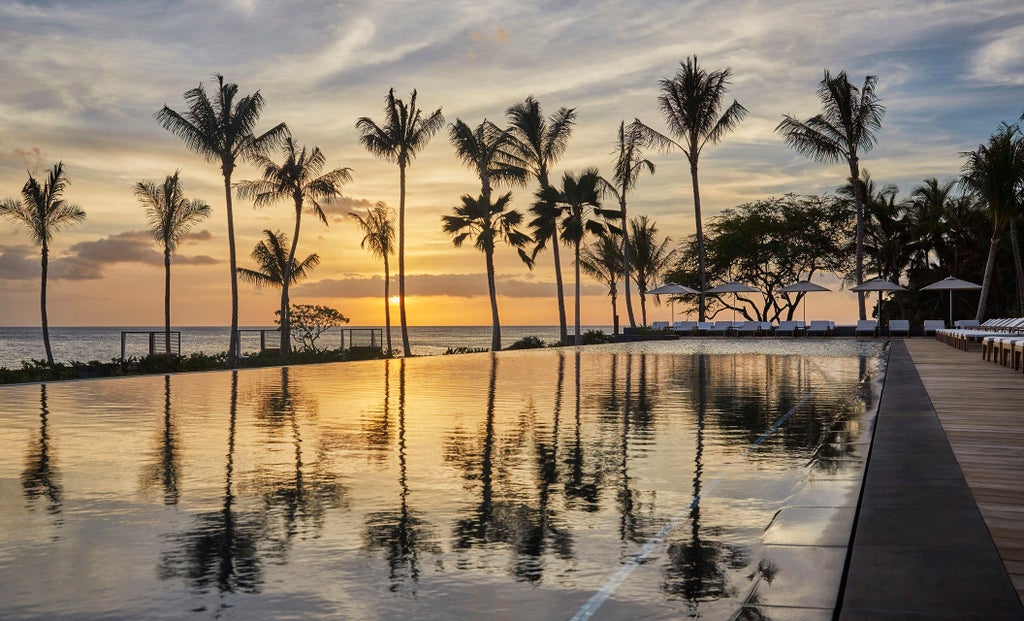 Luxurious oceanfront resort featuring infinity pools, swaying palm trees and private cabanas overlooking turquoise Pacific waters