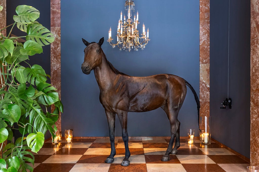 Elegant marble lobby of Grand Ferdinand hotel in Vienna, with grand chandelier, luxurious gold-trimmed furnishings, and classic Austrian architectural details