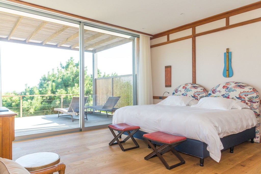 Minimalist beachfront bungalow with sleek design, wooden deck, and panoramic ocean view at luxury Scenset Vik resort in Uruguay