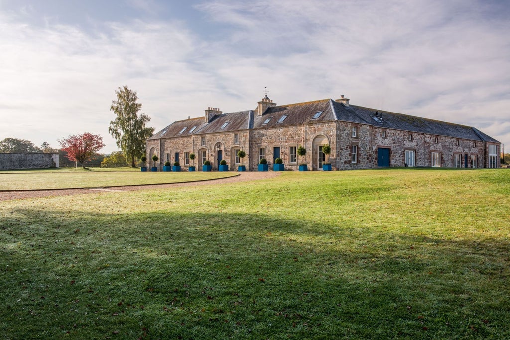 Luxurious stone-built Scottish country house hotel with well-manicured gardens, nestled in scenic countryside with elegant architectural details and pristine landscape