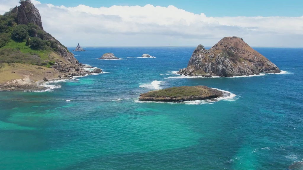 Luxurious coastal hotel with panoramic ocean views, nestled on a cliff in a scenic Brazilian landscape with modern architecture and lush greenery