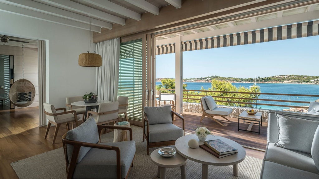 Elegant sea-view suite featuring panoramic Mediterranean views, modern decor, private terrace, and floor-to-ceiling windows at Four Seasons Athens