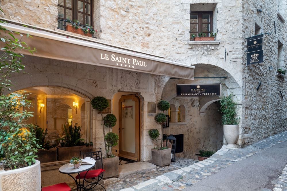 Elegant stone facade of luxurious Hotel Le Saint Paul with classic French architectural details, nestled in a charming historic street in France