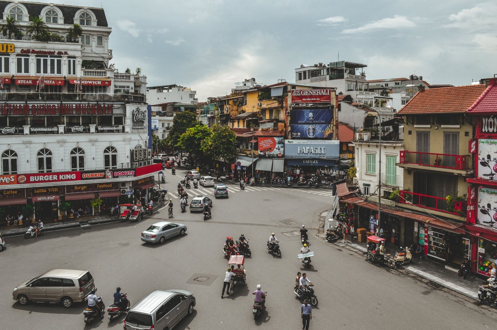 Tourists explore Hanoi's Old Quarter by cyclo, passing traditional shophouses and street vendors beneath colonial French architecture