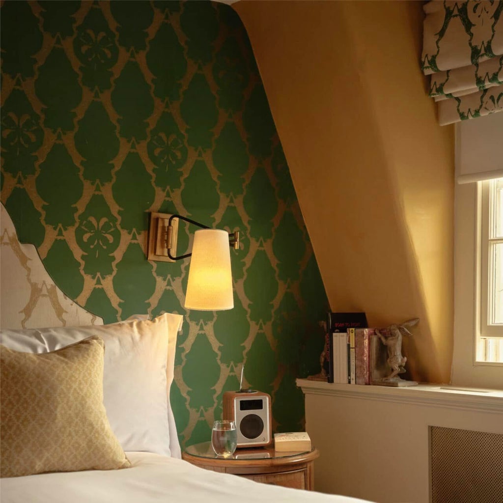 Elegant classic hotel room with soft cream walls, luxurious white linens, period furnishings, and warm wooden accents at The Queensberry Hotel, United Kingdom