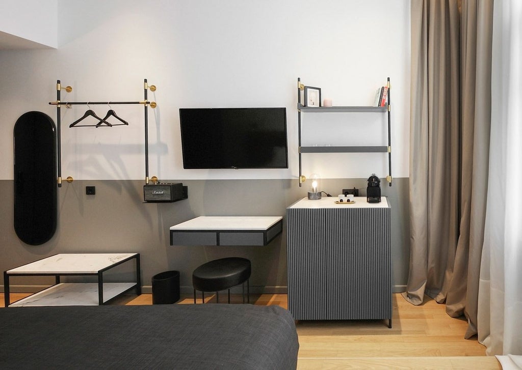 Minimalist medium hotel room with sleek gray decor, modern wooden furnishings, crisp white linens, and floor-to-ceiling window overlooking Thessaloniki cityscape