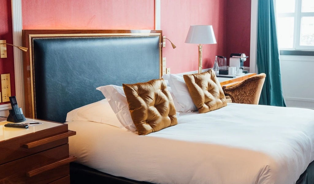 Elegant executive hotel room with panoramic city views, plush king bed, sophisticated neutral decor, and large windows at Le Monumental Palace, Porto