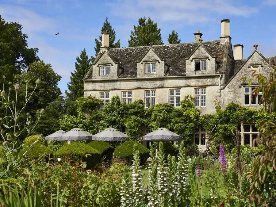 Rustic-chic interior of THE PIG hotel, featuring exposed wooden beams, vintage furnishings, and warm countryside ambiance in a UK rural setting