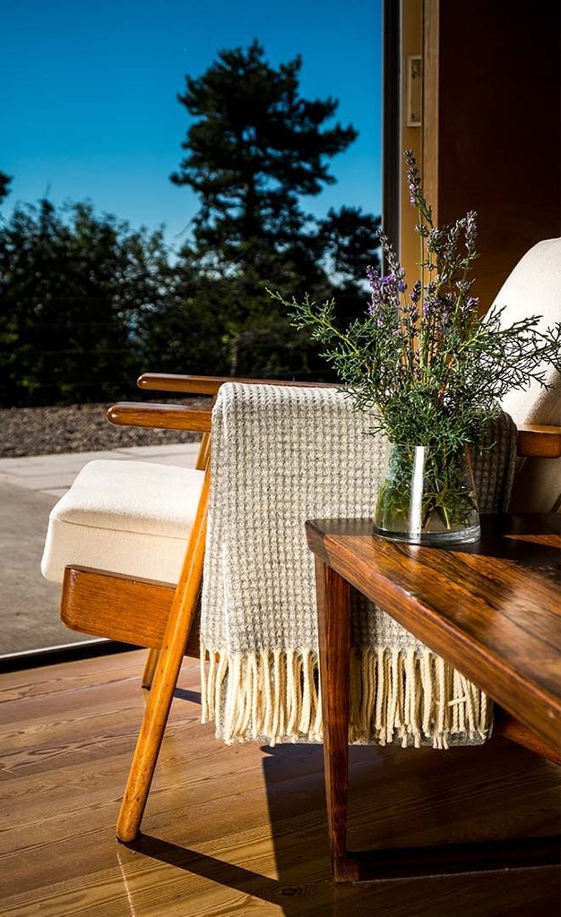 Mountain lodge with minimalist design, panoramic windows overlooking lush Serra da Estrela landscape, blending rustic stone walls with contemporary white interiors