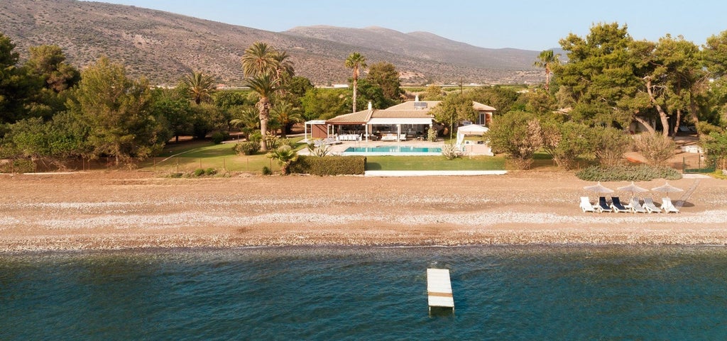 Luxurious Grecian stone villa with terracotta roof, nestled among olive trees, overlooking azure Mediterranean waters with elegant minimal architecture