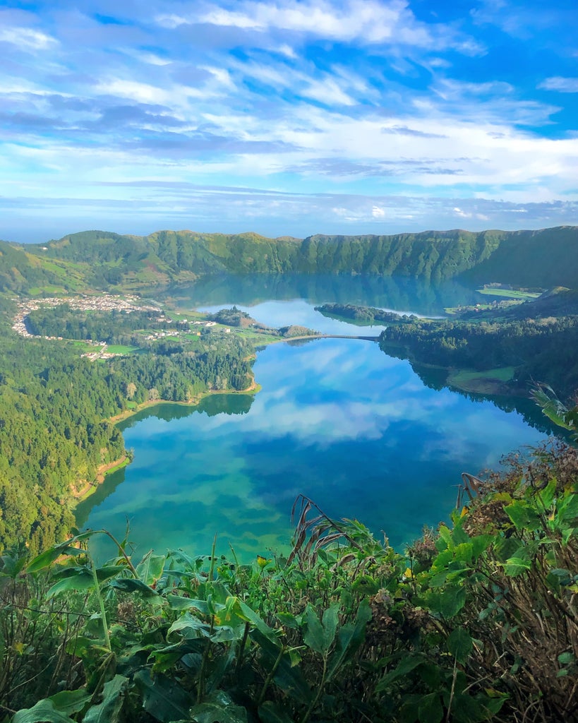 Lush green volcanic crater with twin blue lakes, misty forest paths, and luxurious hiking trail overlooking São Miguel Island's stunning Sete Cidades landscape