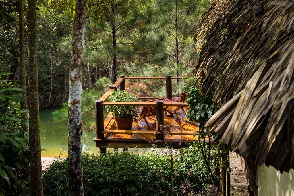 Luxurious eco-lodge nestled in dense Belizean rainforest with thatched-roof villas, tropical gardens, and natural swimming pools