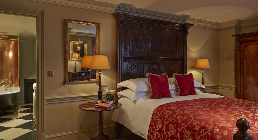 Opulent double bedroom at Batty Langley's with rich dark wood furniture, plush velvet headboard, and elegant Georgian-inspired luxury decor