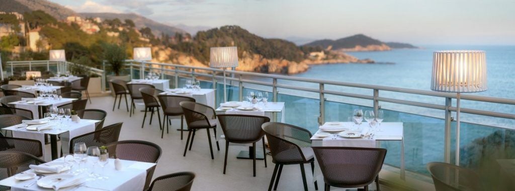 Modern luxury hotel built into cliffside overlooking Adriatic Sea, featuring sleek architecture and private beach access in Dubrovnik